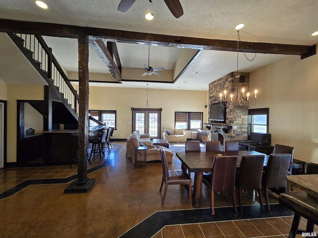 dining space with ceiling fan with notable chandelier, beamed ceiling, and a textured ceiling