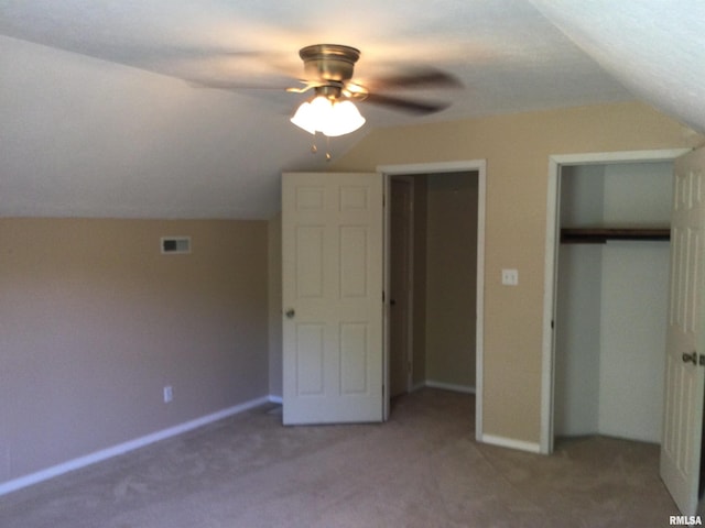 unfurnished bedroom featuring vaulted ceiling, carpet flooring, ceiling fan, and a closet