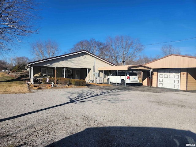 view of front of house featuring aphalt driveway, a detached carport, and a garage