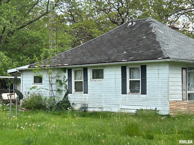 view of side of property featuring roof with shingles