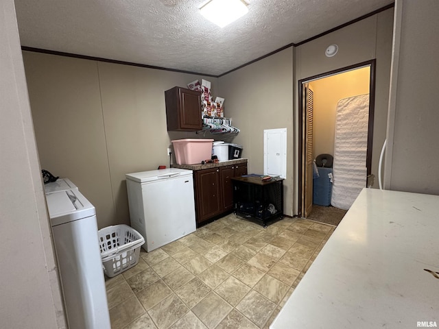 laundry area with washer and clothes dryer, ornamental molding, cabinets, and a textured ceiling