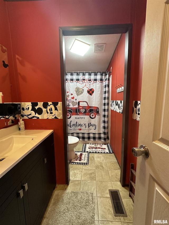 bathroom featuring vanity, toilet, and a textured ceiling