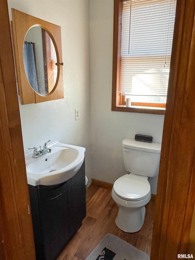 bathroom with hardwood / wood-style flooring, vanity, and toilet