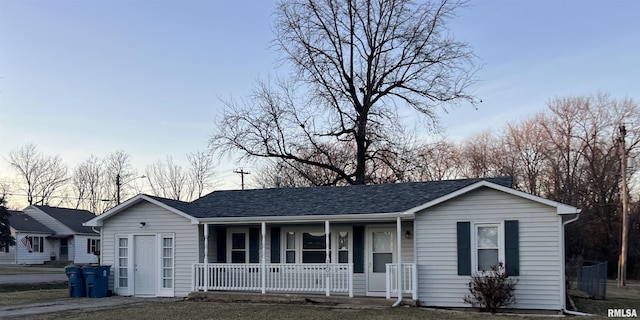 single story home with covered porch and roof with shingles