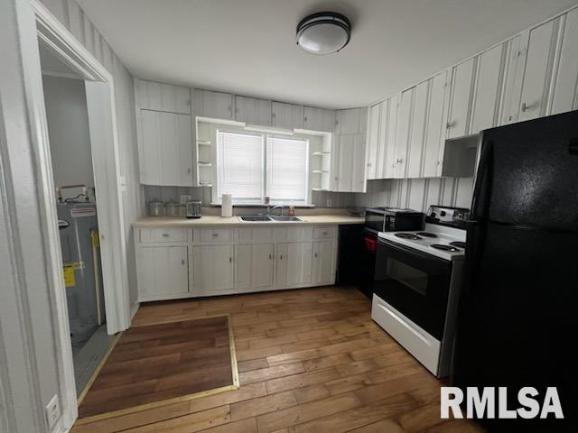 kitchen featuring white cabinetry, electric range oven, sink, and black refrigerator