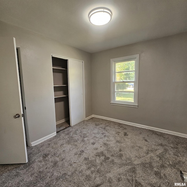 unfurnished bedroom featuring carpet and a closet