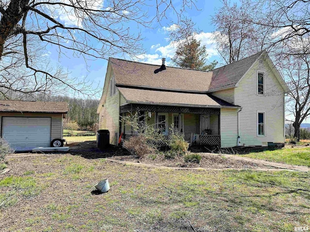 view of front of house with covered porch, an outbuilding, a garage, and roof with shingles
