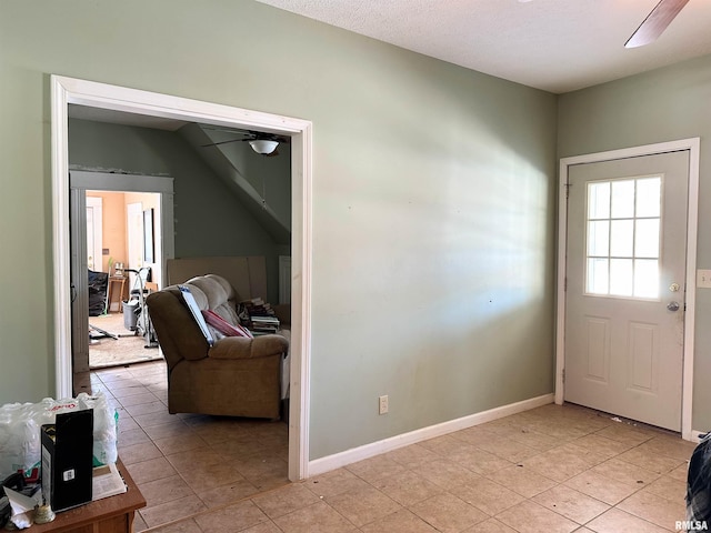 doorway featuring baseboards and ceiling fan