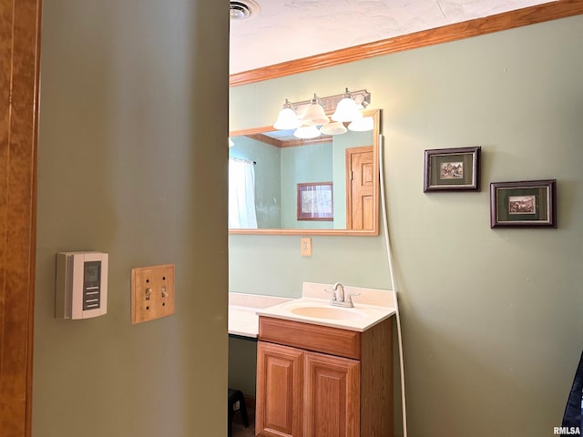 bathroom featuring vanity, crown molding, and visible vents