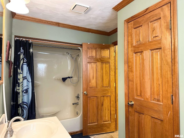 full bathroom featuring a textured ceiling, visible vents, ornamental molding, a sink, and shower / tub combo