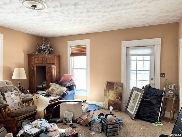 living room with baseboards, carpet flooring, and a textured ceiling