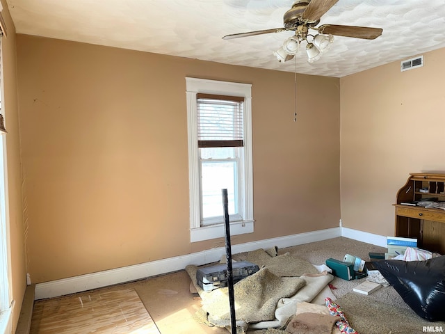spare room featuring baseboards, a textured ceiling, visible vents, a ceiling fan, and wood finished floors