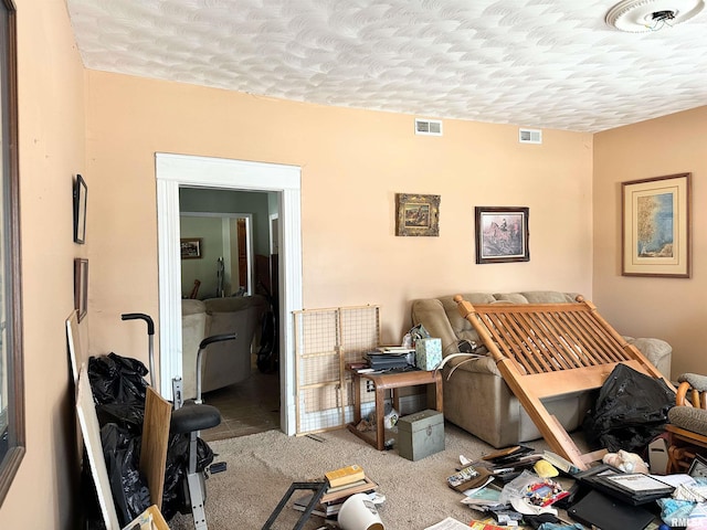 carpeted bedroom featuring visible vents and a textured ceiling
