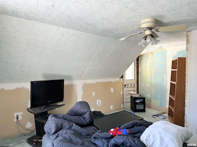 bedroom featuring lofted ceiling, a textured ceiling, and ceiling fan