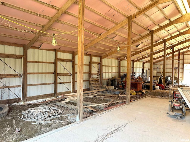 miscellaneous room with metal wall, a garage, and vaulted ceiling