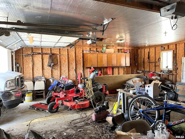 garage with a garage door opener and wooden walls