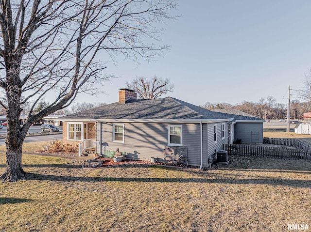 rear view of house with a yard and central AC unit