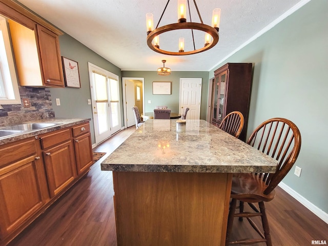 kitchen featuring a breakfast bar area, a notable chandelier, and a center island