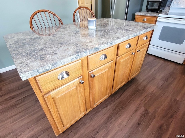 kitchen featuring light stone counters, white range with electric stovetop, a kitchen island, dark hardwood / wood-style flooring, and stainless steel refrigerator