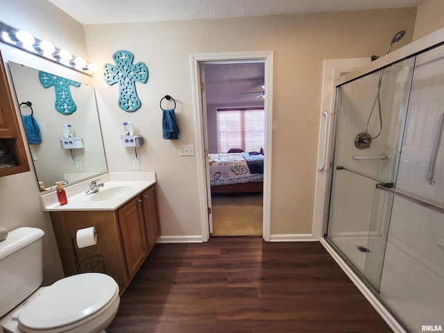 bathroom featuring toilet, a textured ceiling, walk in shower, hardwood / wood-style floors, and vanity