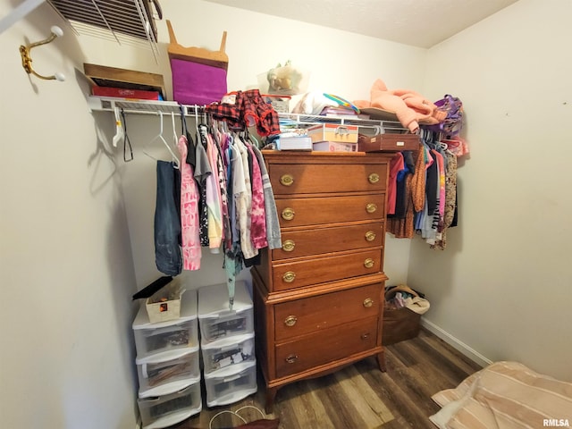 walk in closet with dark hardwood / wood-style flooring