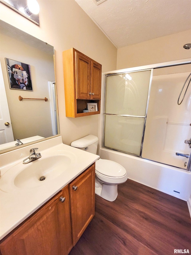 full bathroom with vanity, a textured ceiling, toilet, hardwood / wood-style flooring, and shower / bath combination with glass door