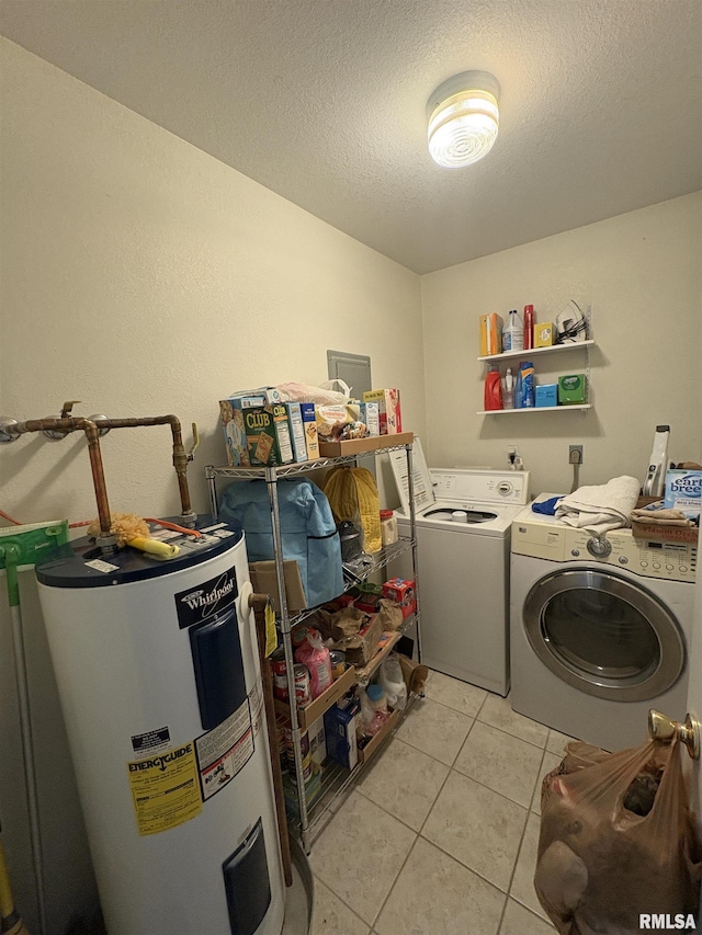 laundry room with light tile patterned flooring, water heater, washer and clothes dryer, and a textured ceiling