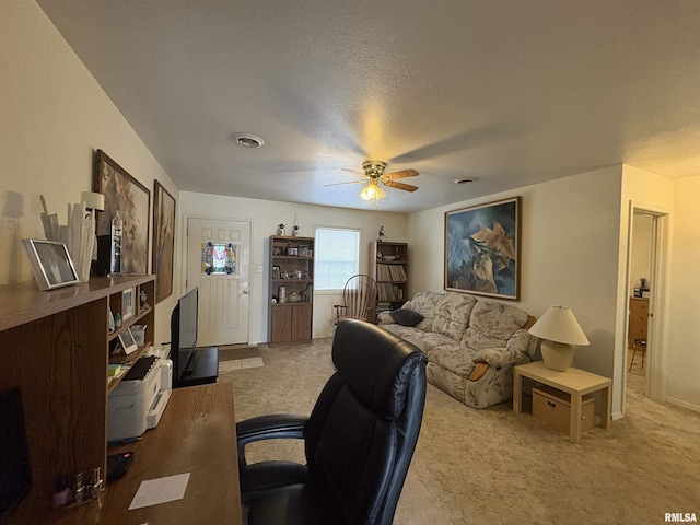 carpeted living room featuring ceiling fan and a textured ceiling