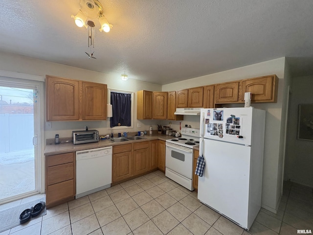 kitchen with sink, white appliances, a textured ceiling, and light tile patterned floors