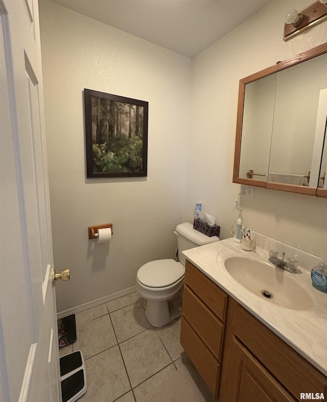 bathroom with toilet, vanity, and tile patterned flooring