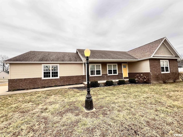 single story home with brick siding, roof with shingles, and a front yard