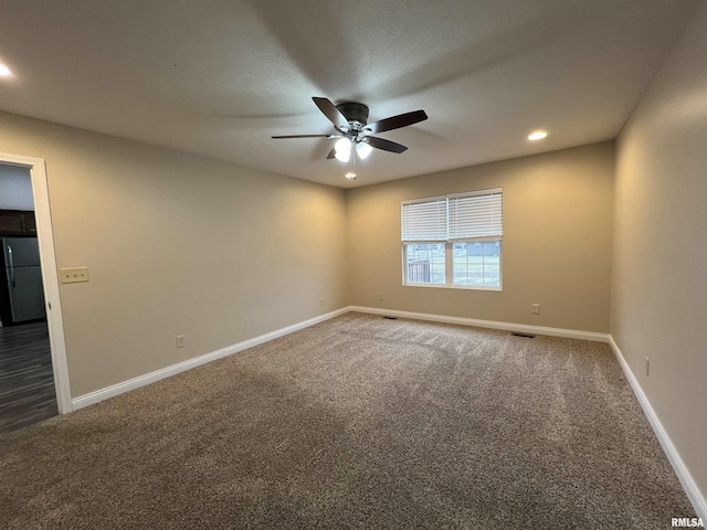 spare room with a ceiling fan, dark colored carpet, baseboards, and recessed lighting