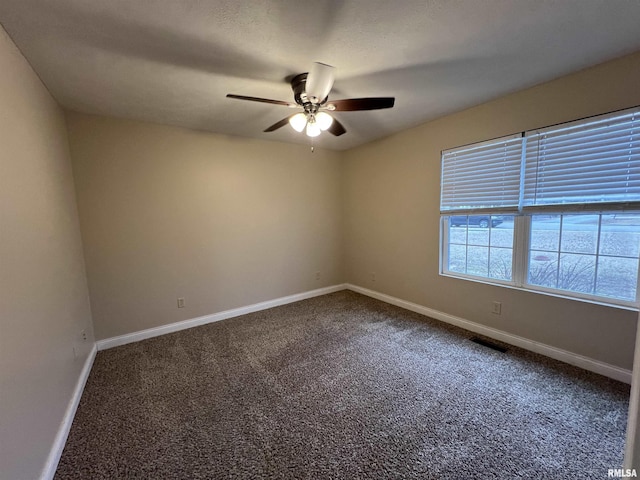 spare room with a ceiling fan, carpet, visible vents, and baseboards