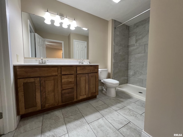 bathroom featuring double vanity, a shower stall, toilet, and a sink