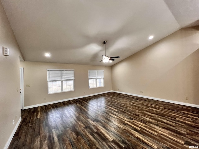 unfurnished living room featuring vaulted ceiling, dark wood-type flooring, and baseboards