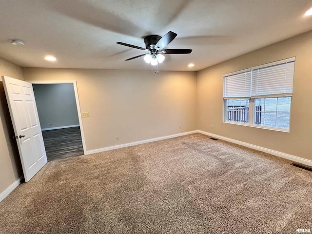 empty room with dark colored carpet, recessed lighting, visible vents, a ceiling fan, and baseboards