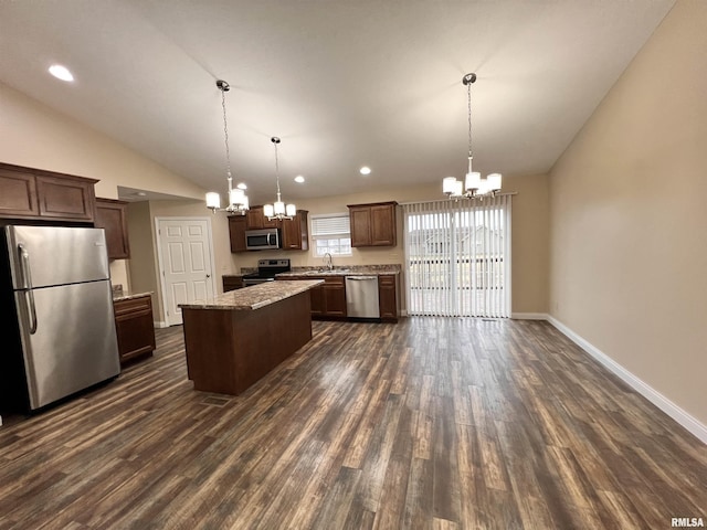 kitchen featuring a kitchen island, appliances with stainless steel finishes, pendant lighting, and a chandelier