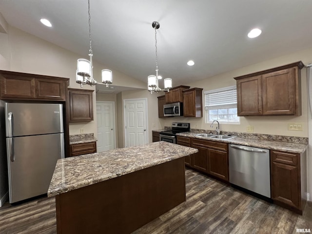 kitchen featuring lofted ceiling, a sink, appliances with stainless steel finishes, a center island, and pendant lighting