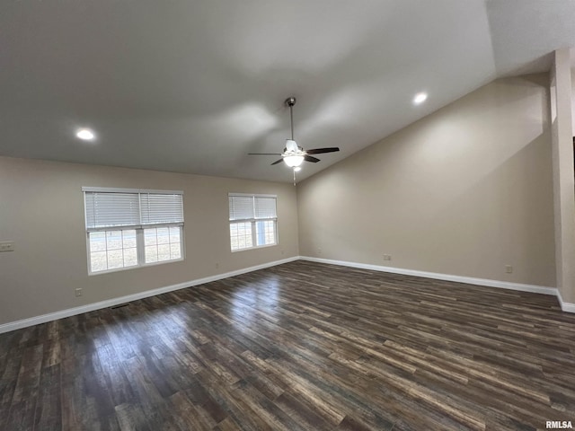 spare room with lofted ceiling, dark wood-style floors, ceiling fan, and baseboards