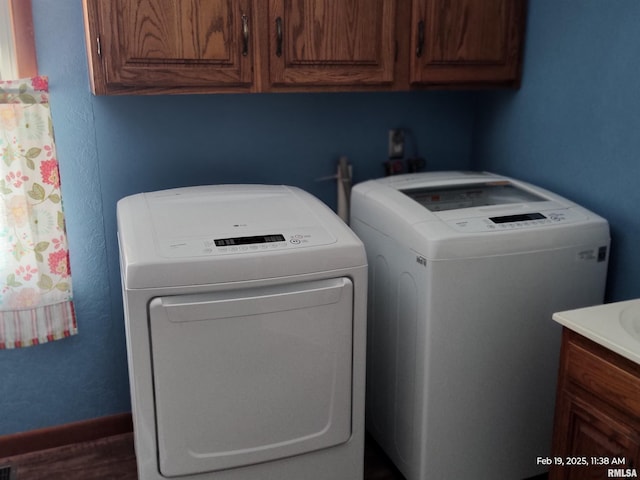 laundry area with cabinets and washing machine and clothes dryer