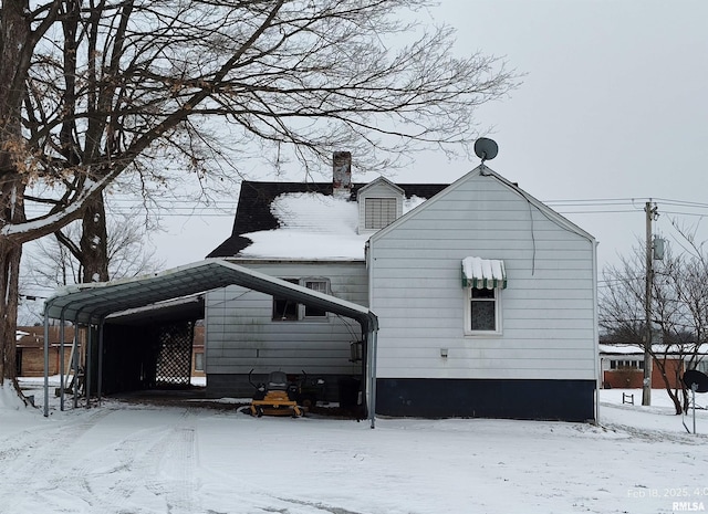 view of snow covered exterior featuring a carport