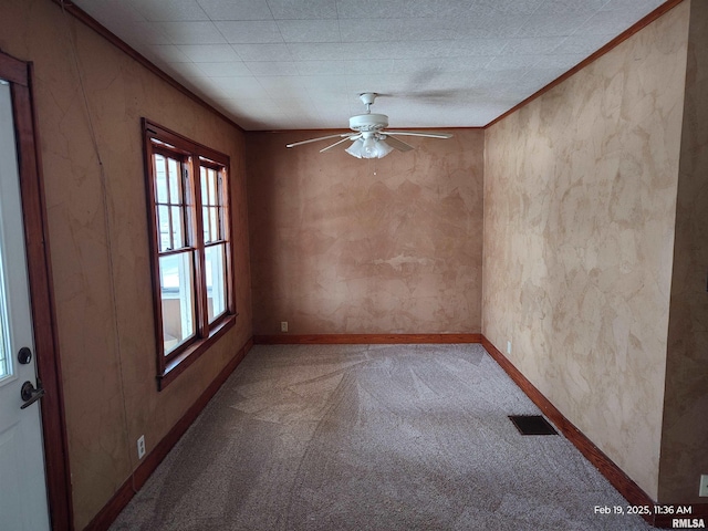 unfurnished room featuring ceiling fan, ornamental molding, and carpet floors