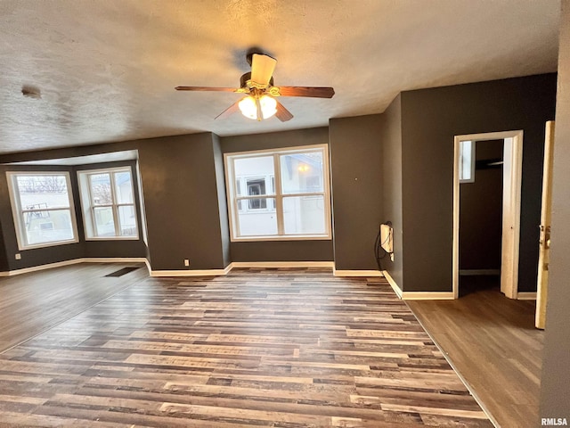 unfurnished living room with hardwood / wood-style flooring, ceiling fan, and a textured ceiling