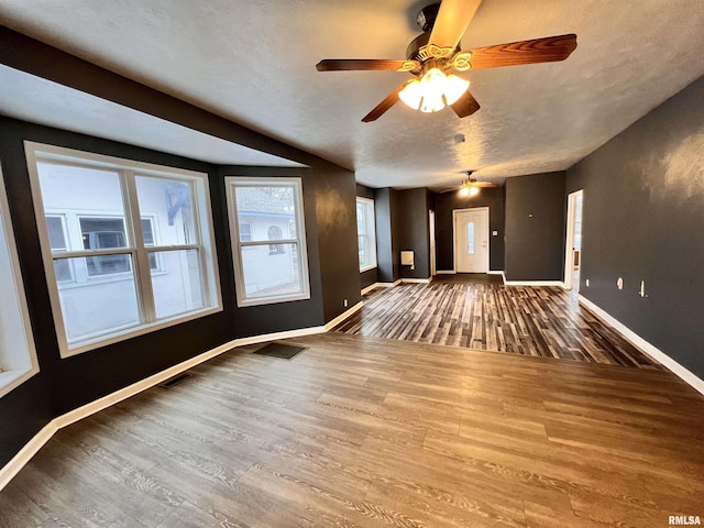 unfurnished living room featuring hardwood / wood-style floors and a textured ceiling