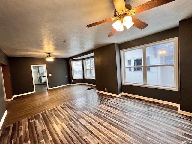 unfurnished living room with dark hardwood / wood-style flooring, ceiling fan, and a textured ceiling