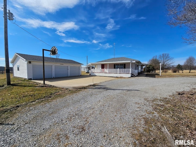 view of front of property featuring a garage, covered porch, and an outdoor structure