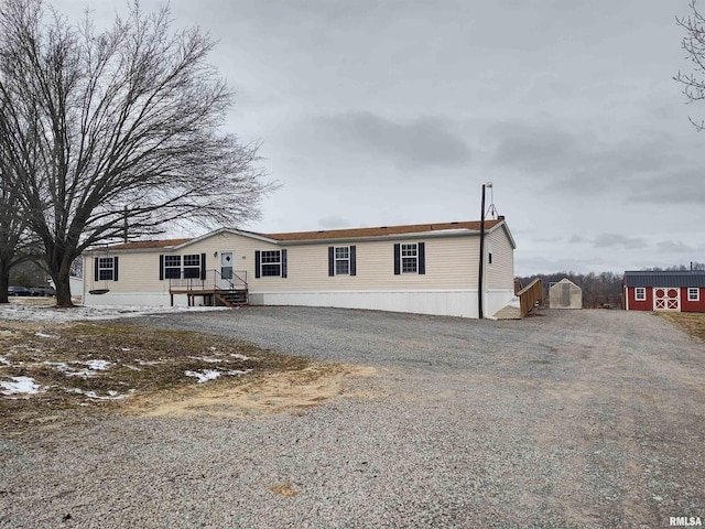 manufactured / mobile home featuring driveway and an outdoor structure