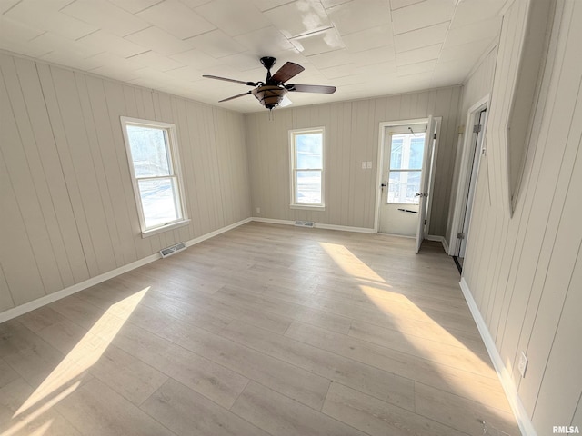 unfurnished room featuring a ceiling fan, baseboards, visible vents, and light wood finished floors