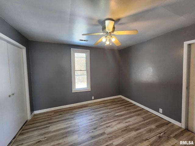 unfurnished bedroom featuring a closet, wood finished floors, and visible vents