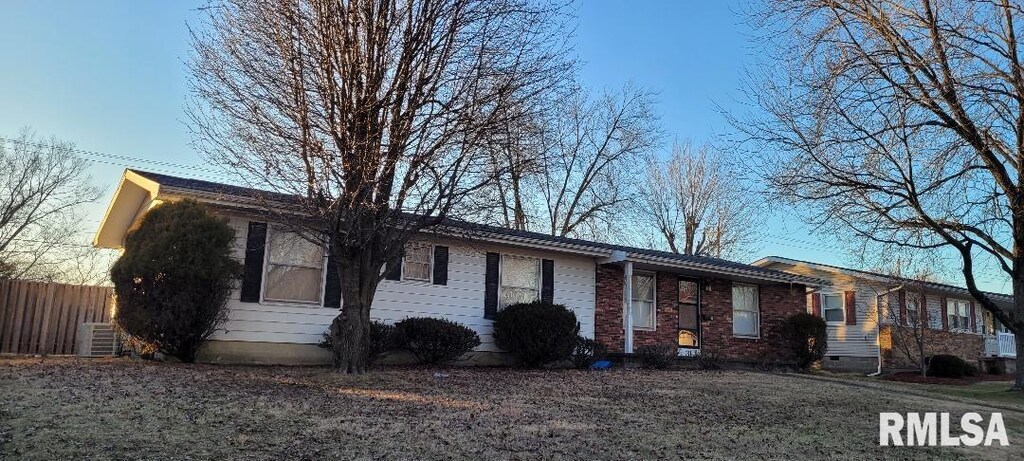 single story home with brick siding, cooling unit, and fence